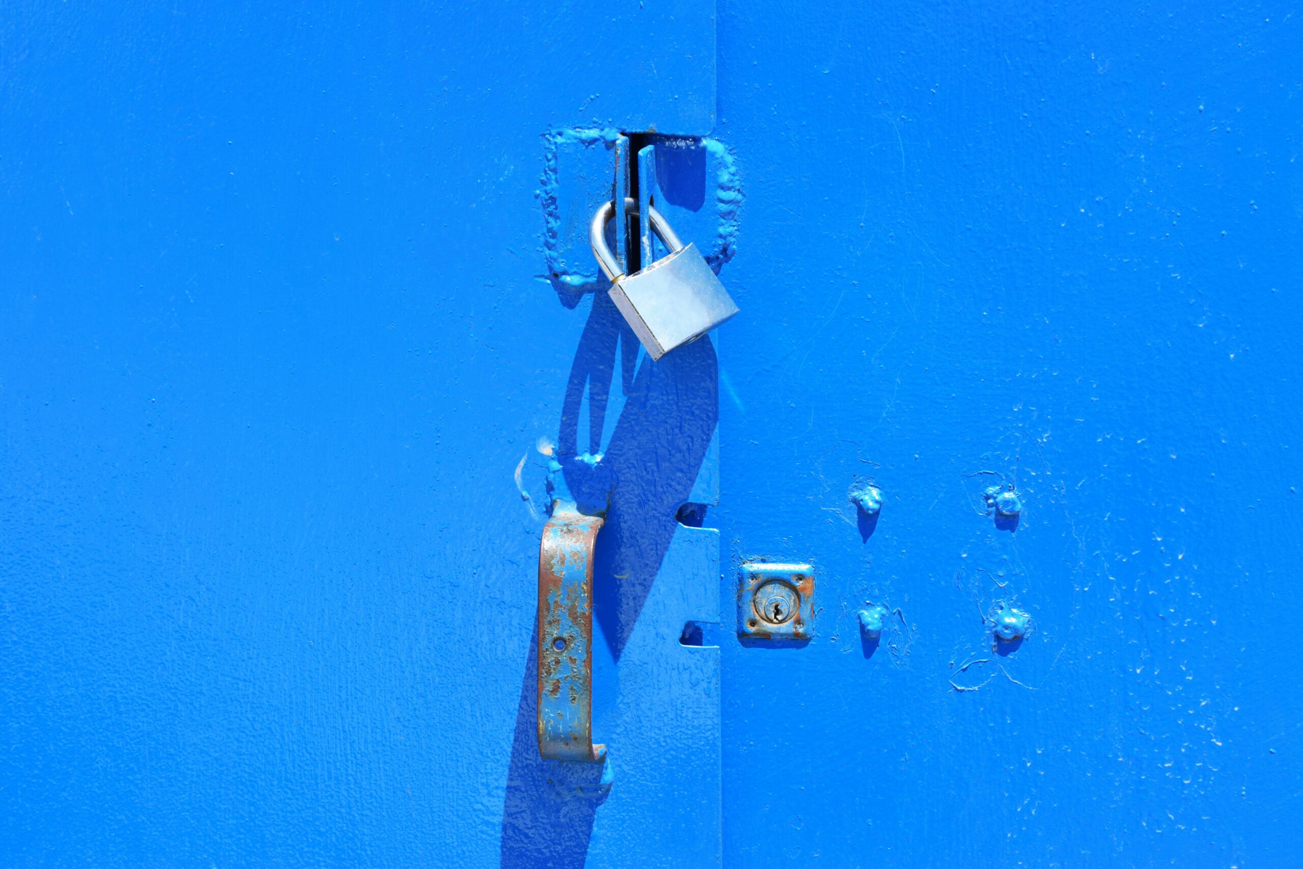 Blue metal cabinat held shut with a padlock.